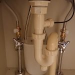 洗面台収納内の給水管と排水トラップ